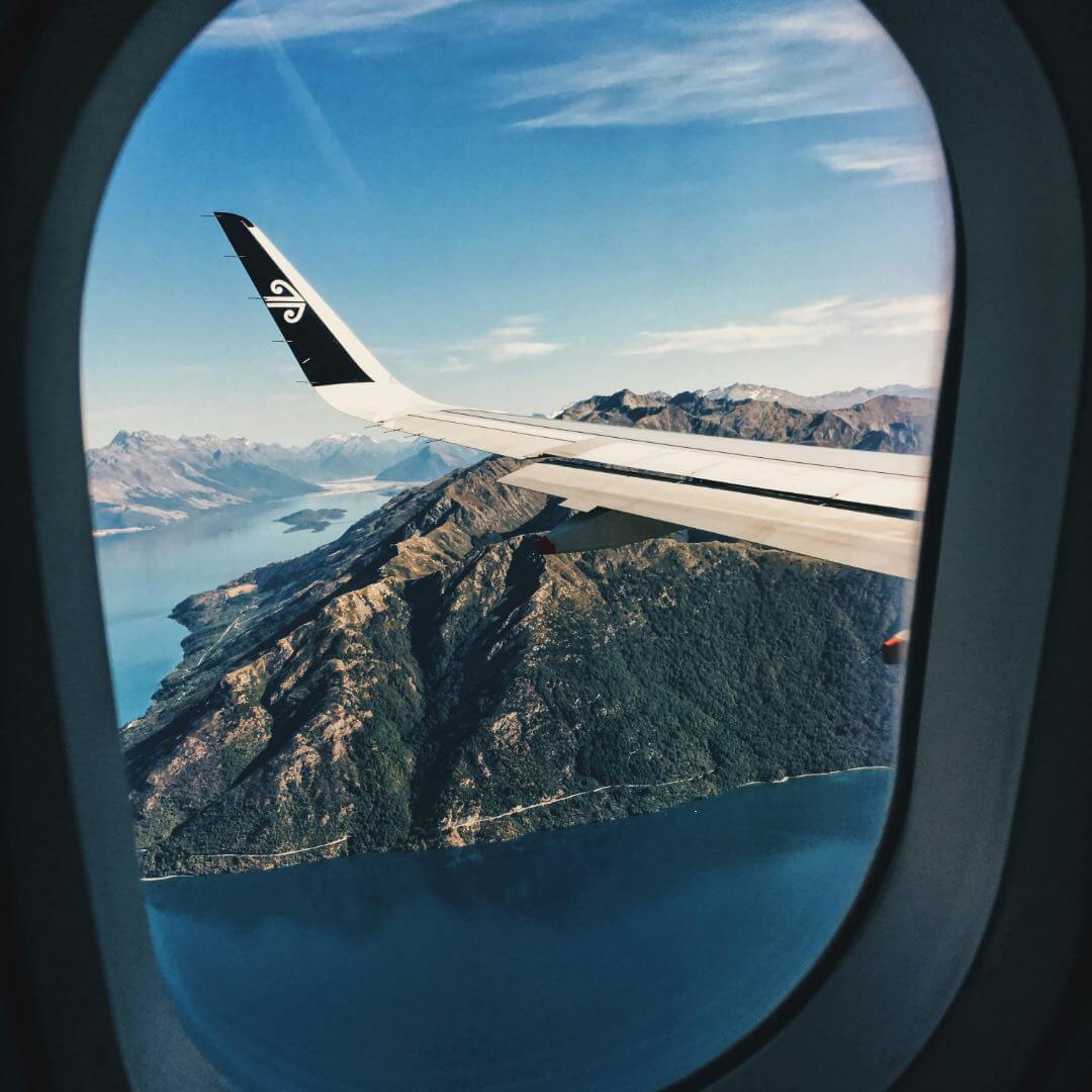 Blick aus Flugzeug auf Landschaft und Wasser.